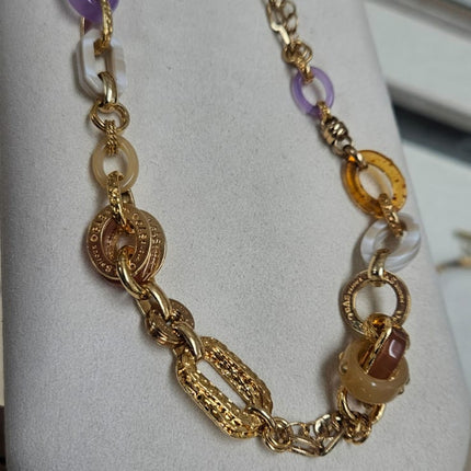 Collar compuesto por una fina cadena bañada en oro, adornado con delicadas piedras preciosas. 