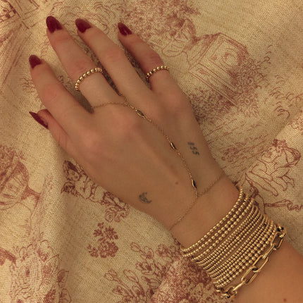 Joyería hand chain resistente al agua en gold filled de 14k con detalles de topacio blanco