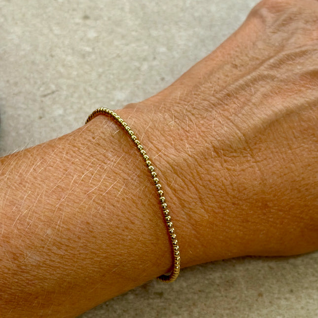 Pulsera en oro 14K gold filled de 2 mm, con un brillo sutil que acompaña la muñeca con naturalidad.