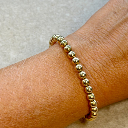 Pulsera de bolitas 5 mm en oro 14K gold filled, con un brillo continuo que aporta un punto de atención definido en la muñeca.