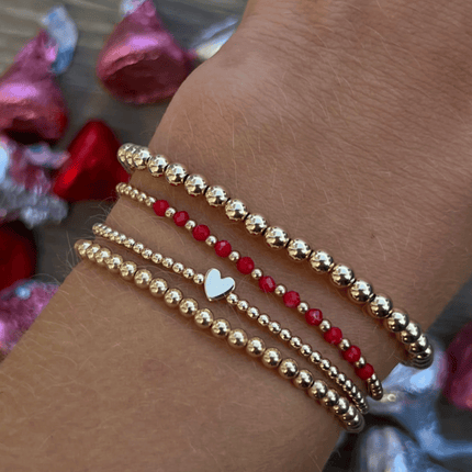 Pulsera de oro con corazón en oro sólido de 14K, acompañada por cuentas de 5 mm en gold filled que aportan estructura y equilibrio.