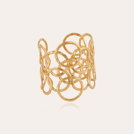 Brazalete Olympia, bañado en oro fino, elaborado con una elegante superposición de anillos martillados a mano en nuestro taller de Marsella.