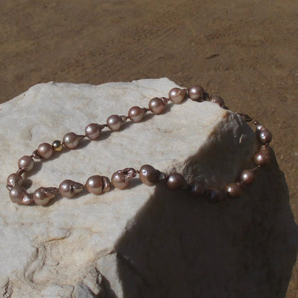 Collar de perlas barrocas de agua dulce en tono marrón claro de 8 mm, acentuadas con una cuenta texturizada de 8 mm en oro 14K gold filled que aporta un contraste sutil.