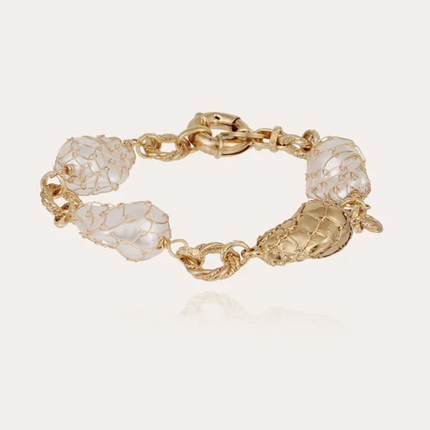 Pulsera bañada en oro , compuesta por finos anillos ensamblados con delicadas cuentas de resina perlada ligeras, montadas sobre un engarce.